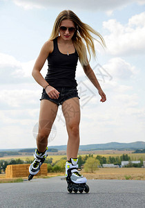 旱冰鞋的十几岁的女孩马路上的直排轮滑背景图片