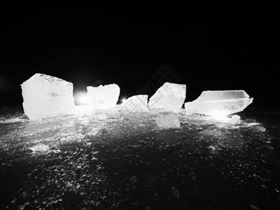 在黑暗的自然背景上的一块碎冰铺设在深色浮冰上的黑白图片