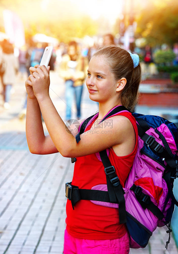 带着背包在智能手机上自拍的旅游女孩和城市文化展地露天步行街道图片