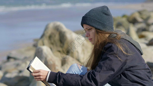 女孩坐在海滨看书图片