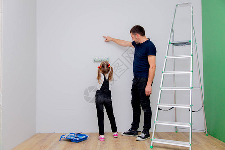 父亲教女儿如何粉刷墙壁背景图片