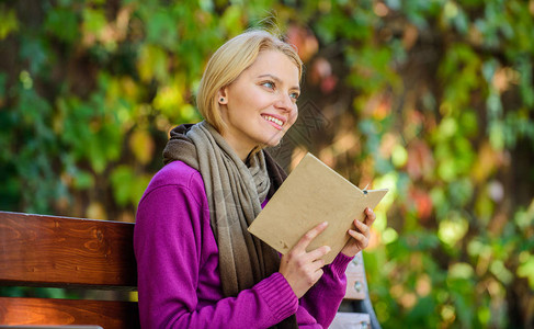 女孩坐在长凳上放松与书秋天自然背景秋季书单智力爱好书虫夫人在秋天的一天在户外看书女人看书秋图片