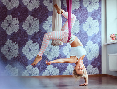 女在健身俱乐部的紫色吊床做图片