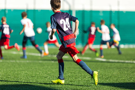 少年足球比赛穿着蓝色和白色运动服的男孩在踢足球比赛背景中的图片