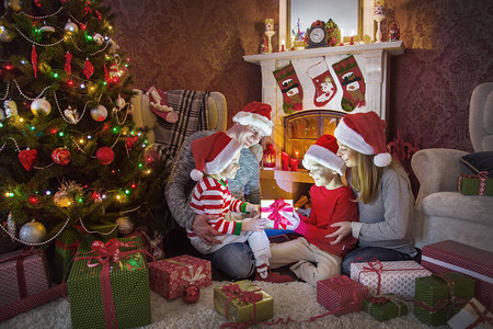 幸福的家庭在圣诞树下面壁炉附近庆祝圣诞节图片