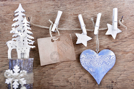 用于消息和圣诞装饰的纸签挂在木制背景上的一根绳子上图片