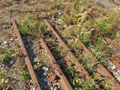 废弃火车站的老旧生锈铁路铁轨之间有图片