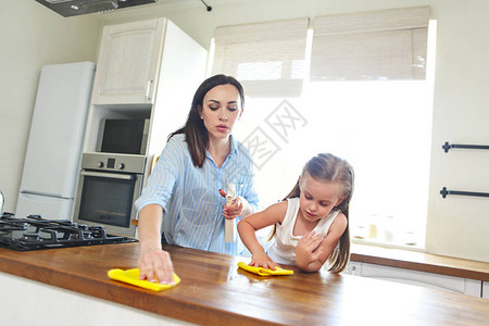 美丽的女儿和母亲打扫厨房图片