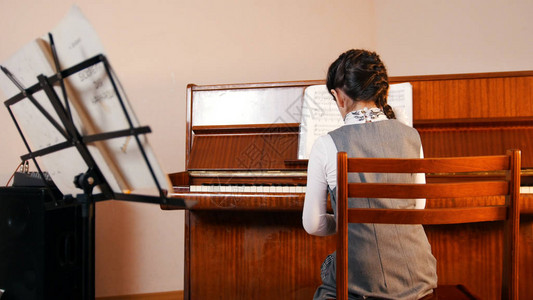一个小女孩在音乐课上弹钢琴图片