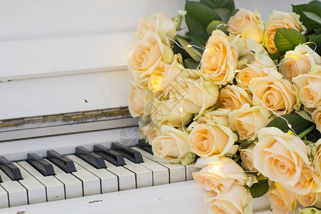 钢琴生日素材白色钢琴上带花环的桃玫瑰背景