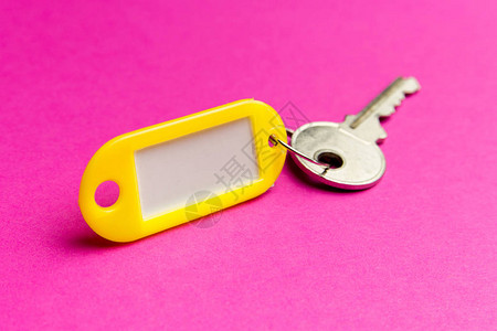 紫色纹理纸板背景上的黄色钥匙标签图片