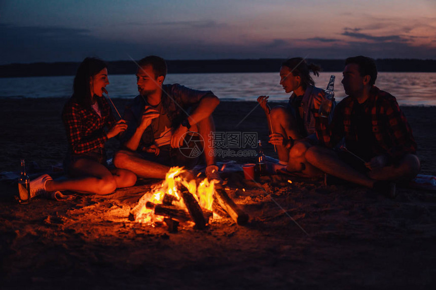 一群年轻朋友在野餐和营火图片