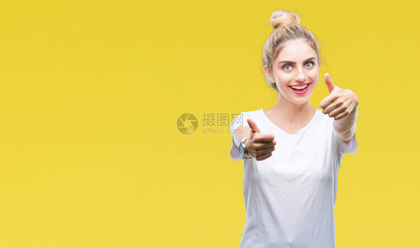年轻漂亮的金发女郎穿着白色T恤在孤立的背景下批准用手做积极的手势图片