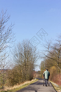 高级男子在自行车上驾驶滚动车在南德的蓝天和阳背景图片