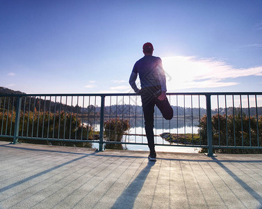 赛跑者在海湾大桥上做伸展运动一个活跃的瘦子站在一条腿图片