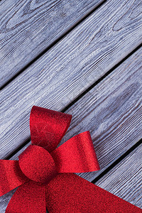 大红圣诞弓在有文字空间的生锈木板上图片