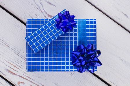 白色木制背景上的深蓝色礼物盒图片