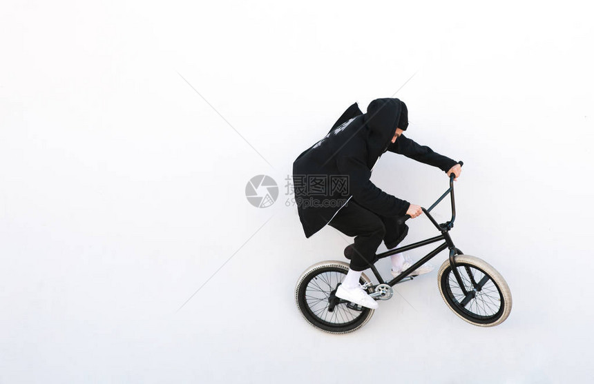 穿着深色衣服的Bmx骑自行车者骑在白色背景上在白色背景上孤立的bmx自行车上的自行车骑手小轮车概念Cop图片