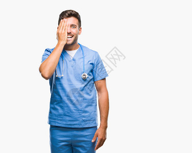 年轻英俊的外科医生身处孤立的背景一只眼睛用手满怀自信的笑容图片
