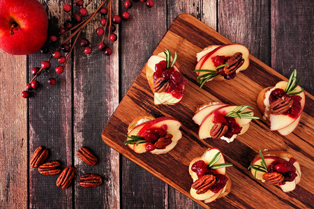 克罗斯蒂尼开胃菜有苹果红莓树莓和核桃在木盘上的图片