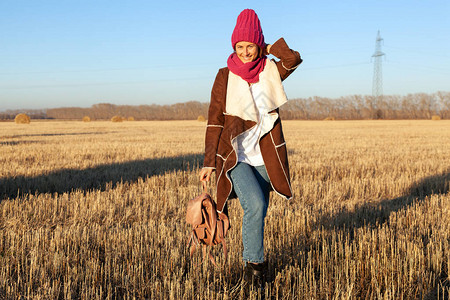 年轻时尚女时尚生活方式肖像穿着温暖时尚的衣服和针织帽子在田野里笑着快图片