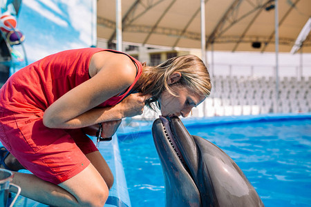 与海豚接吻的女人亲吻宽海豚的女教练图片