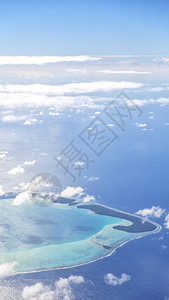 从飞机云层和海洋中可以看到珊瑚礁的景背景图片