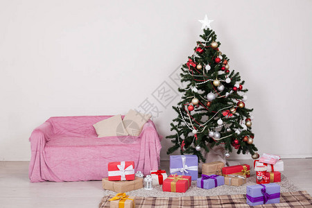 在白色房间的圣诞树配有圣诞节装饰品和图片