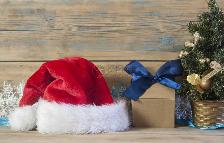 木桌背景上有装饰品和礼物的圣诞树图片