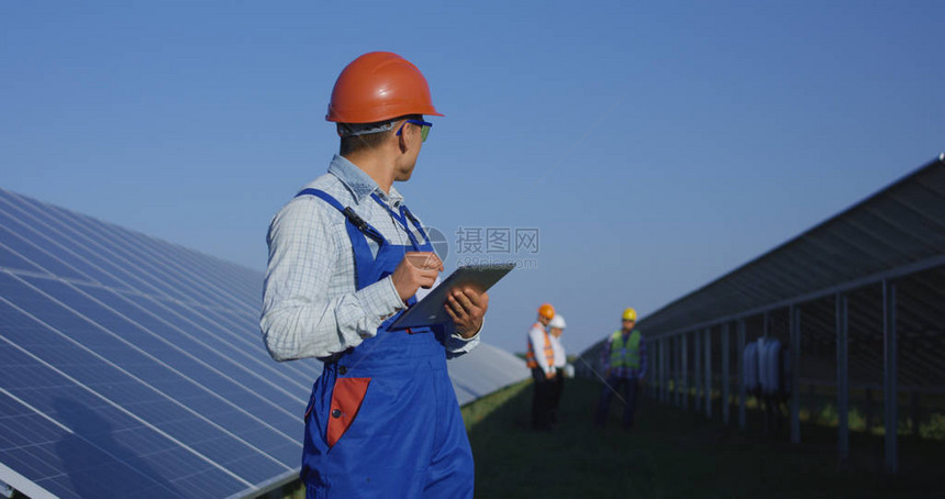 朝鲜青年男子在整体上和硬汉中使用阳光下的平板石图片