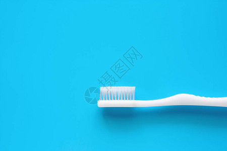 白牙刷用于为牙科护理概念在蓝背景图片