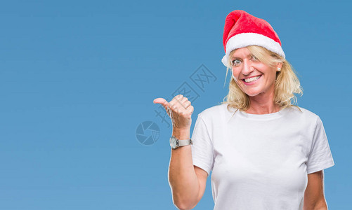 身戴圣诞帽的中年金发女郎在孤立的中微笑图片