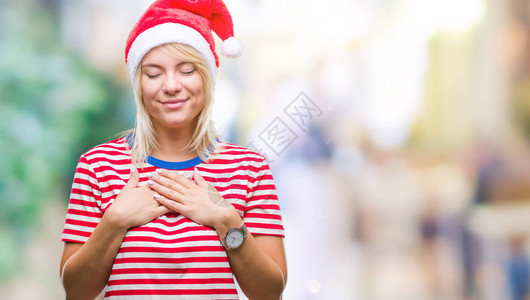 穿着圣诞帽的年轻金发美女在孤立的中微笑图片