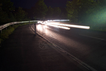 夜间交通高速公路角上的白光轨图片
