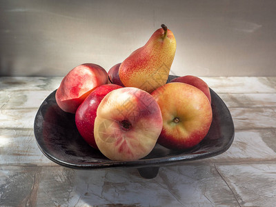 黑盘中的水果葡萄酒梨子苹果都放在图片