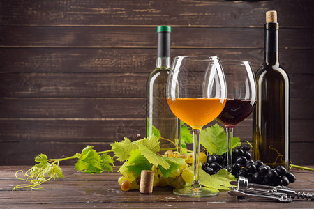 木桌上的酒瓶和葡萄图片