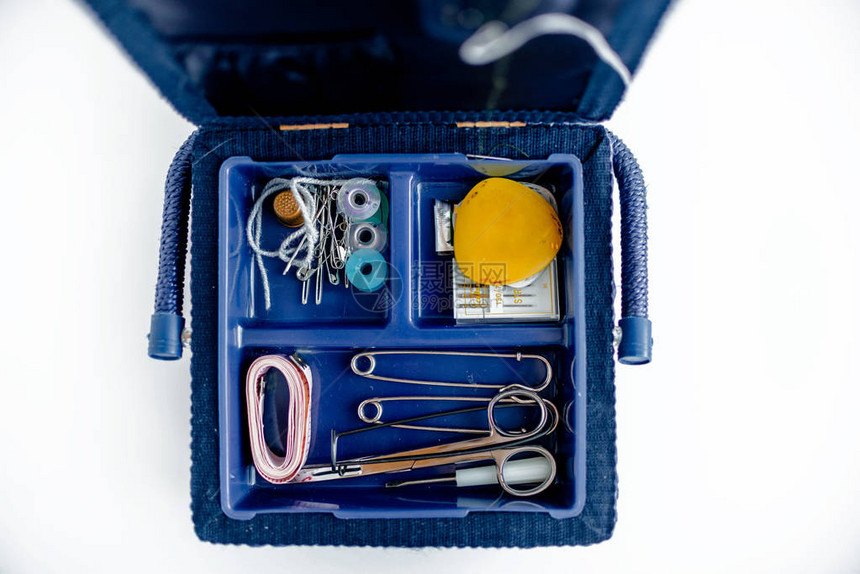 带有缝纫和针织用品的缝纫工具包缝纫工具包和蓝色缝纫盒孤立的白色背景图片