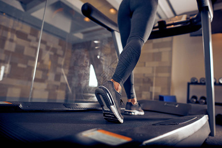 女人的腿紧贴在跑步机上跑动图片