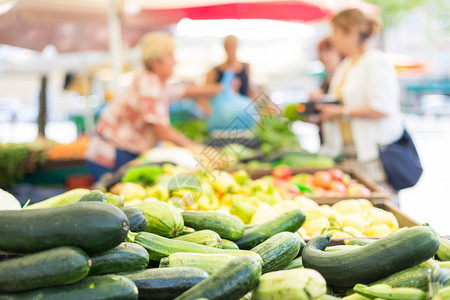 模糊随机未识别的人在城市农贸市场摊位购买每日新鲜健康的自产蔬菜图片