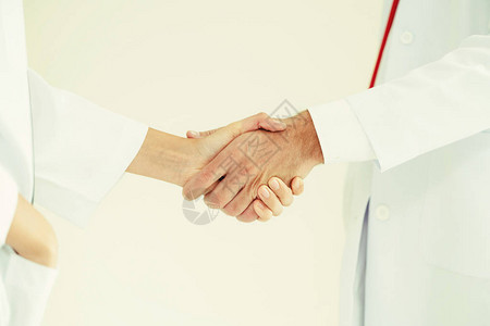 白色背景的医生与另一位医生握手图片