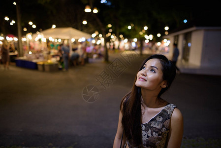 年轻快乐美丽的亚洲年轻女在泰国华欣夜市上微笑与思考高清图片
