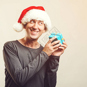 助手帽子的快乐人与礼品盒寒假和圣诞节的概念拆包礼物圣诞礼物快乐的打开盒子背景图片