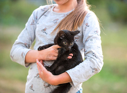 金发女孩抱着可爱的黑小猫图片