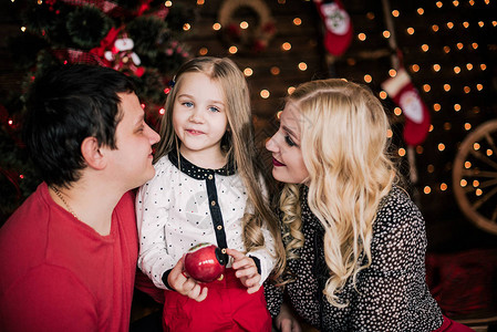 穿着红色衣服的漂亮年轻家庭在圣诞假期一起玩乐图片