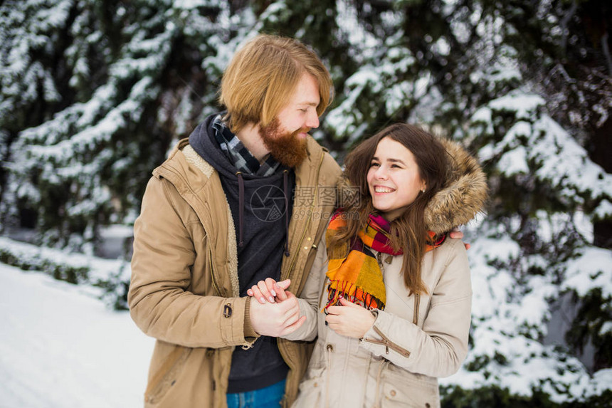 年轻的高加索男孩和女孩相爱的异恋夫妇在冬季公园户外约会图片