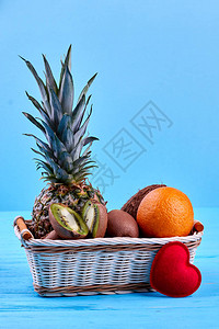 柳条篮中有机水果的成分蓝色背景上的一组健康异国水果对于水果爱好者图片