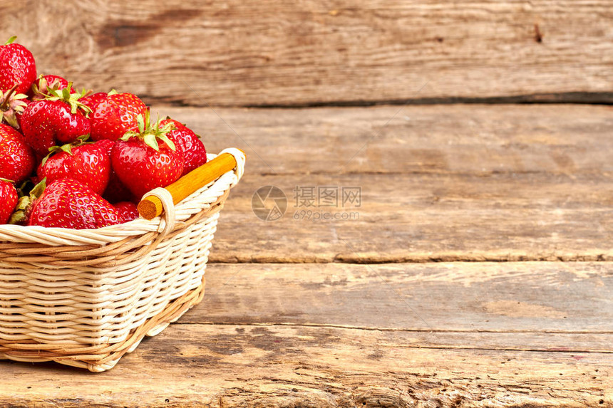 新鲜的香草莓和复制空间在生锈木质表面和文字空间上配有草莓的篮子图片
