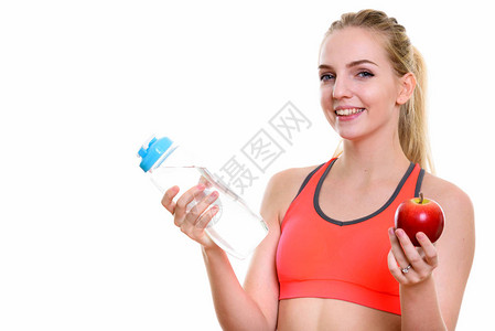 年轻快乐的少女在装水瓶和红苹果准备健图片