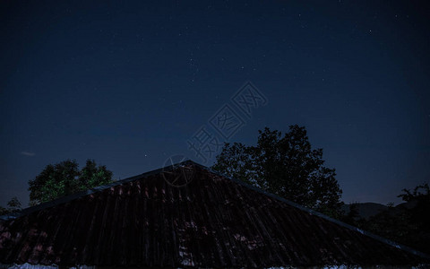 美丽的夜景与星夜山和森林有绿色草甸和山的夜森林在明亮的星夜图片