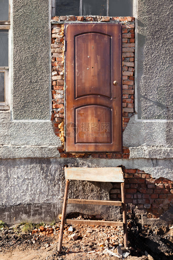 被毁建筑的入口木门金属楼梯旧木框窗户红砖灰色混凝土概念纹理背景废图片